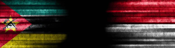 モザンビークとインドネシアの黒い背景の旗 — ストック写真
