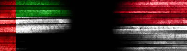 阿拉伯联合酋长国和印度尼西亚关于黑人背景的旗帜 — 图库照片