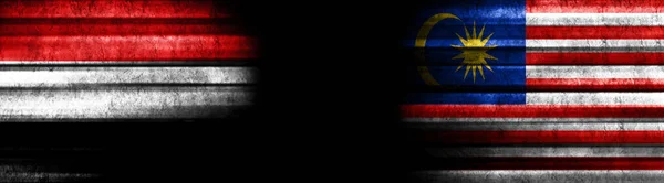 イエメンとマレーシアの黒い背景の旗 — ストック写真
