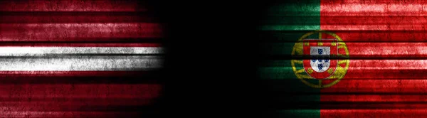 ブラックバックグラウンドのラトビアとポルトガルの旗 — ストック写真