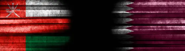 黒い背景のオマーンとカタールの旗 — ストック写真