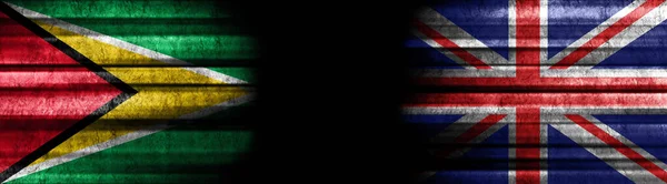 ガイアナとイギリス 黒い背景の旗 — ストック写真