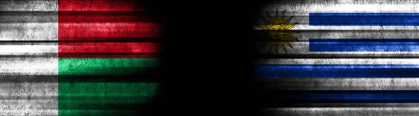 黒い背景のマダガスカルとウルグアイの旗 — ストック写真