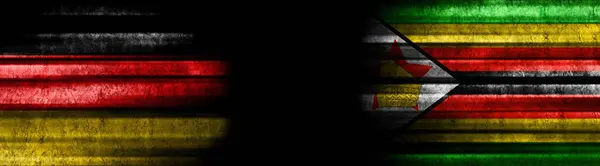 黒い背景のドイツとジンバブエの旗 — ストック写真