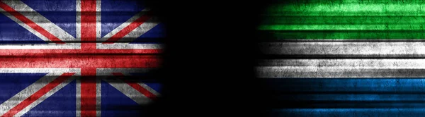 イギリスとシエラレオネの黒い背景の旗 — ストック写真