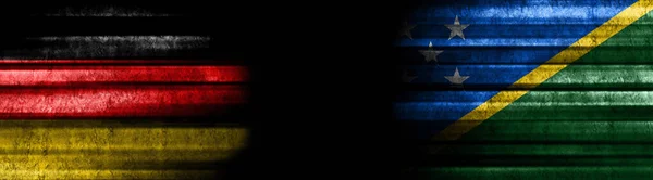 黒い背景にドイツとソロモン諸島の旗 — ストック写真