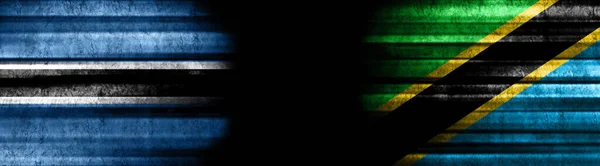 黒い背景のボツワナとタンザニアの旗 — ストック写真