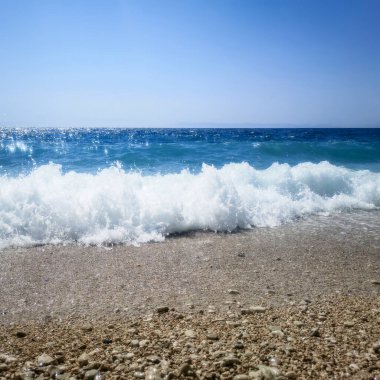 Kumlu kumsalda Mavi Okyanus Dalgası Yaz Arkaplanı