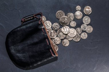 Deri bir kese dolusu eski gümüş para hazinesi.