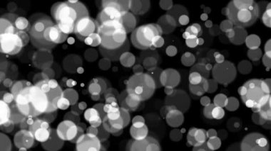 Siyah arkaplanda soyut beyaz parıltı ve parçacık. Siyah arkaplanda güzel beyaz bokeh ile döngülenmiş animasyon.