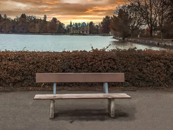 Thunersee, Bern Kantonu 'ndaki Thun yakınlarında Schadau Kalesi' nin önündeki ahşap bank.