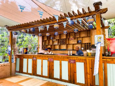 Oktoberfest kutlaması için hazırlanan açık hava restoranı ve bar. Ve garsonlar Doha, Katar OCT 04.2024 'te geleneksel kıyafetlerini giyiyorlar.