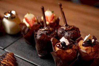 Siyah kesim tahtası ve ahşap arka planda kek kekleri. 