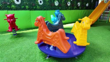 Dönen neşeli çocuk parkında ve arka planda sarı kaydırak.