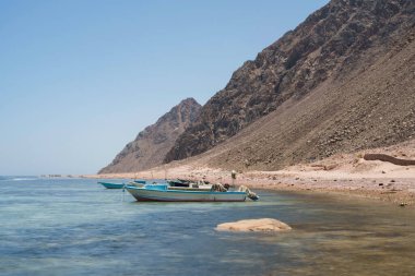 Geleneksel balıkçı tekneleri kayalık kızıl deniz kıyısının yakınına demir attı. Dahab, Mısır