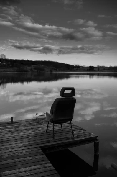 釣り場と椅子のある湖と桟橋の白黒写真 — ストック写真