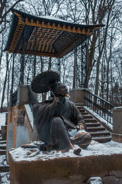 公園内の中国橋の近くに傘を中国人のブロンズ彫刻 Bila Tserkva ウクライナのPark Oleksandriya — ストック写真