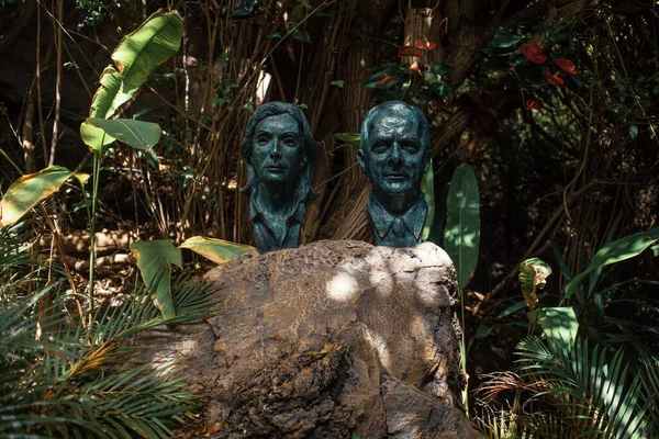 Human head sculptures in tropical garden