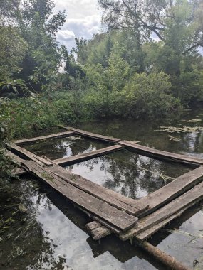 Üzerinde tahta bir köprü olan bir gölet.