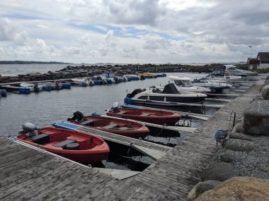Sahilde farklı tekneleri olan ahşap iskele. 