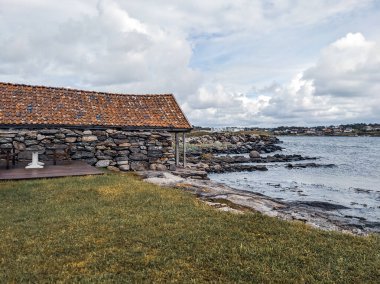 Sahildeki eski ahşap evin manzarası.