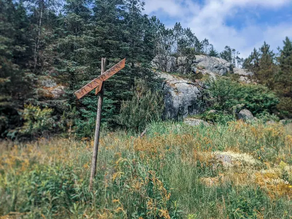 stock image Wooden signpost in mountain landscape with rock formations, Trollpikken, Egersund in Norway, Europe