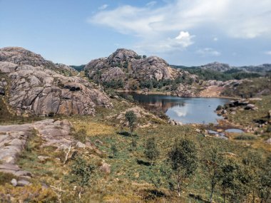 Giant rocks in the Norwegian mountains with lake, Trollpikken, Egersund in Norway, Europe  clipart