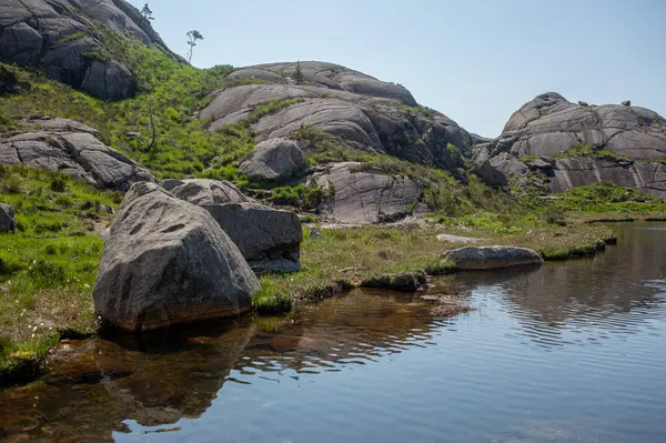 Norveç 'in dağlarındaki dev kayalar. Göl, Trollpikken, Norveç, Avrupa' daki Egersund. 