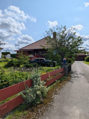 Kırsal kesimdeki evin yanında siyah retro araba.