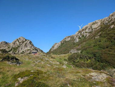 Rock formations with windmills on the background,  Trollpikken, Norway, Europe clipart