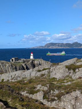 Uçurumdaki deniz fenerinin güzel manzarası ve gemiyle denizin kıyısı.