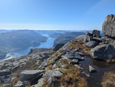 Dağları, mavi gökyüzünü ve nehri olan güzel bir manzara.