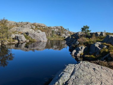 Dağları, mavi gökyüzünü ve nehri olan güzel bir manzara.