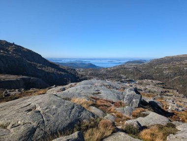 Dağları, mavi gökyüzünü ve nehri olan güzel bir manzara.