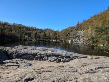 Dağları, mavi gökyüzünü ve nehri olan güzel bir manzara.