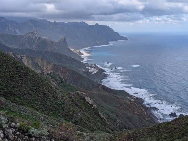 Güzel kayalık kıyı şeridi ve kabarık bulutlu gökyüzü. 