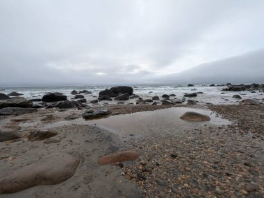 Stormy atmosphere over coastal stone beach