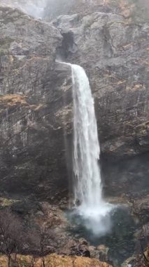 Şelale buharının manzarası ormandaki dağ kayalarından aşağıya doğru ilerliyor. 