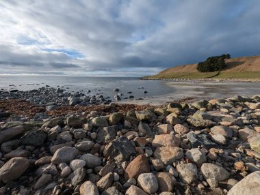 Stormy atmosphere over coastal stone beach