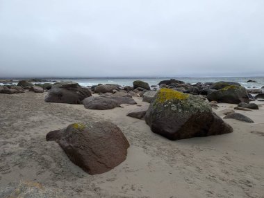Clouded sky over ocean-washed stones