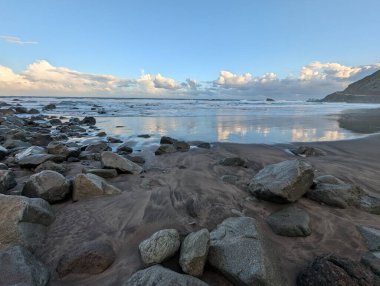 Güneşli kayalık deniz manzarası ve güzel gün batımı gökyüzü