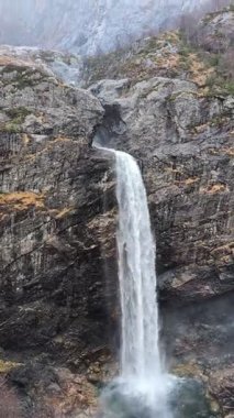Şelale buharının manzarası ormandaki dağ kayalarından aşağıya doğru ilerliyor. 