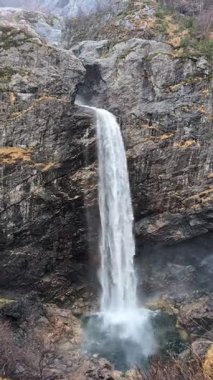 Şelale buharının manzarası ormandaki dağ kayalarından aşağıya doğru ilerliyor. 