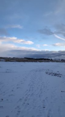 Sahilde kayalar kışın karla kaplı. 