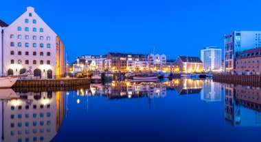 Binalar, Gdansk Polonya 'da şafakta Motlawa nehrindeki suya yansıyor.