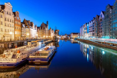 Binalar, Gdansk Polonya 'da şafakta Motlawa nehrindeki suya yansıyor.