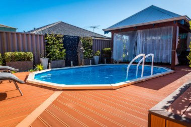 Perth, WA / Avustralya - 08 / 19 / 2019 Yerüstü havuzu yerin altına gömüldü ve güverte ile çevrili.