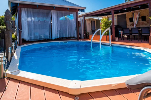 Perth, WA / Avustralya - 08 / 19 / 2019 Yerüstü havuzu yerin altına gömüldü ve güverte ile çevrili.