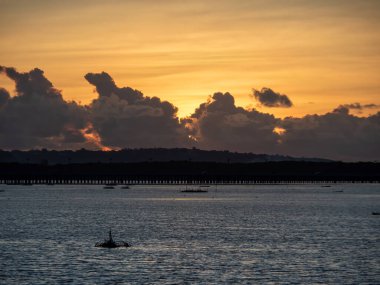 Benoa Körfezi 'nde gün batımında arkada Toll Köprüsü var. Bali, Endonezya