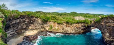 Nusa Penida 'nın kayalık kıyı şeridi. Denizin üzerinde taş kemer. Kırık plaj, Nusa Penida, Endonezya